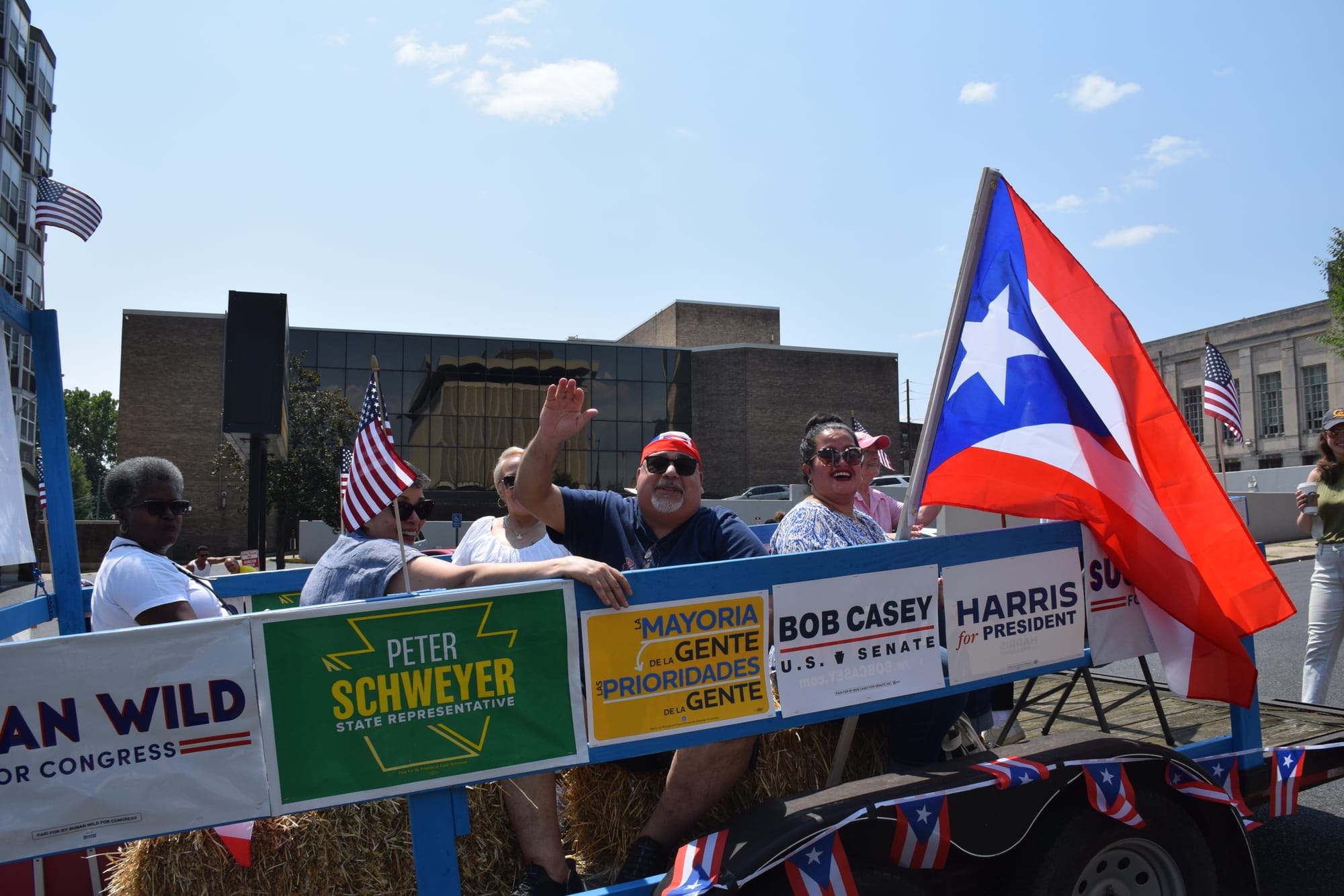 Guillermo Lopez (waving) rides on a float with Democrats including U.S. Rep Susan Wild at Allentown's Puerto Rican parade on 