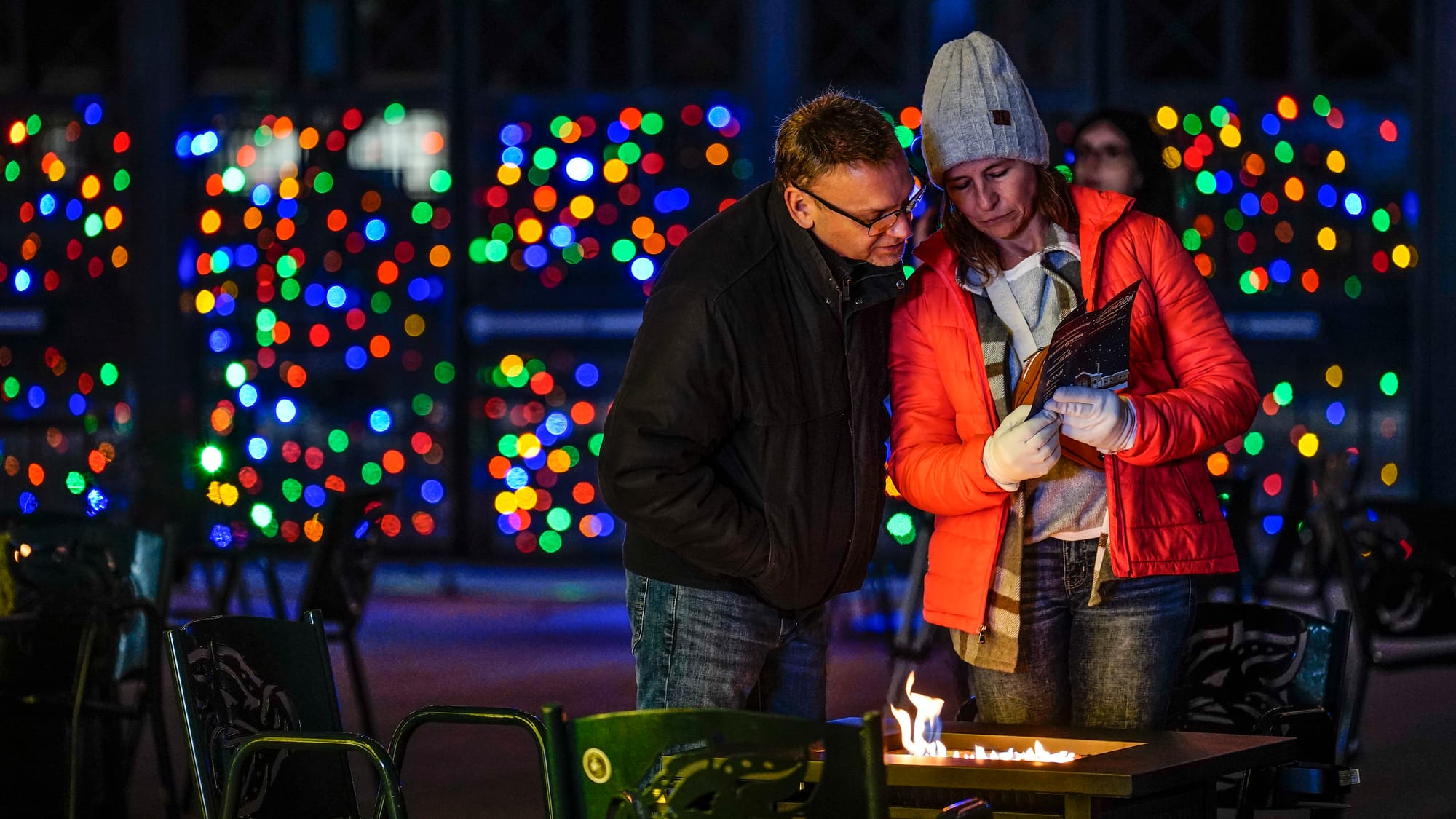 Lee and Krista Sandt of Bethlehem warm up by a fire. The Lehigh Valley IronPigs are hosting Illumination, a display of brilli
