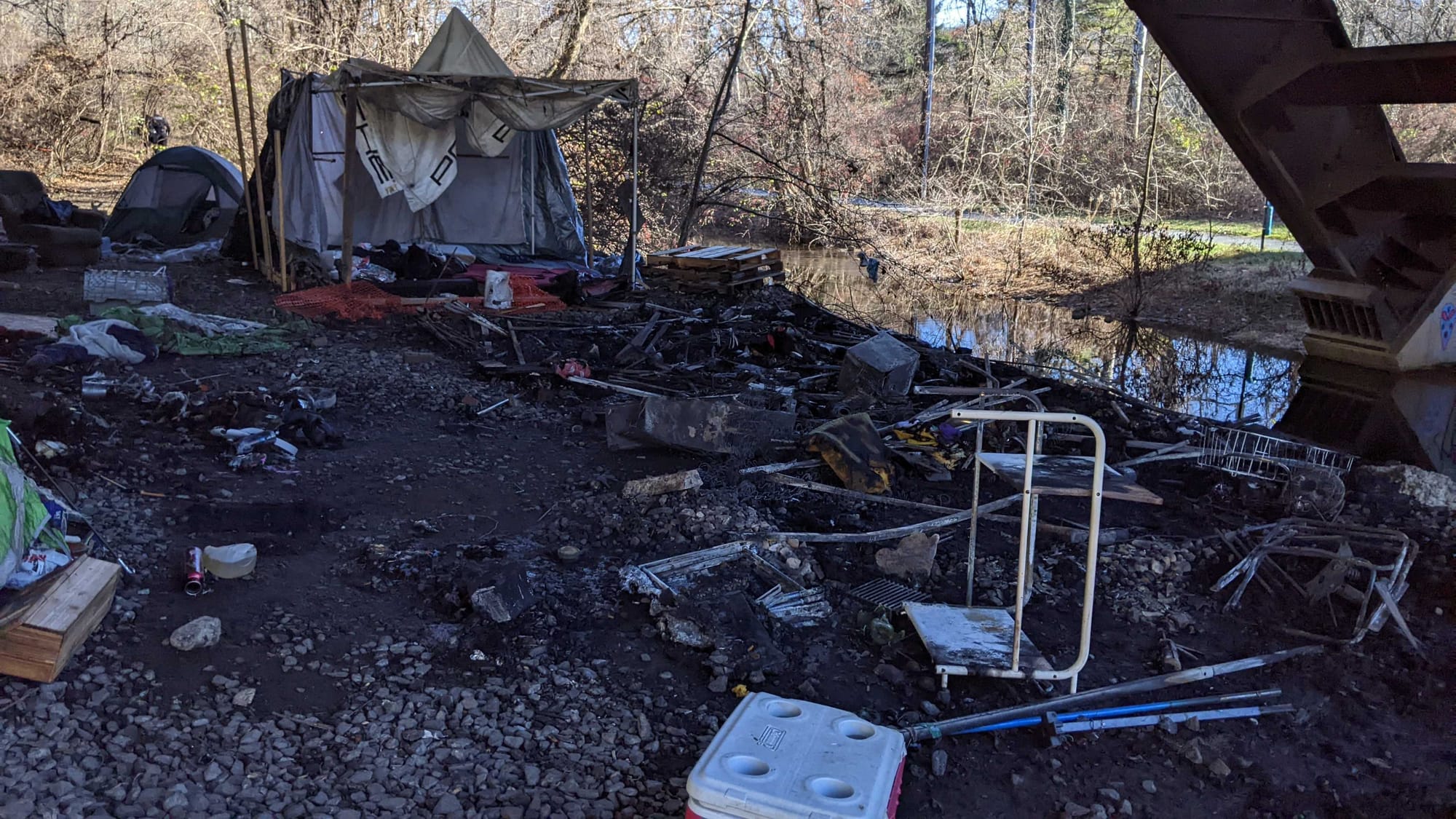 Police say two adult men were found with burns to their arms and hands following an early morning fire at an encampment under
