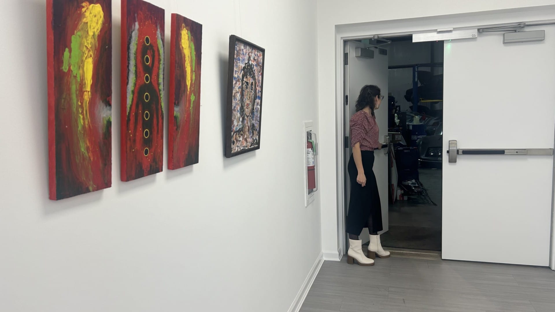 Nina Boodhansingh peeks into the garage at Vollux Autowerks from the showroom, which hosts Midnight Art Gallery in Schnecksvi
