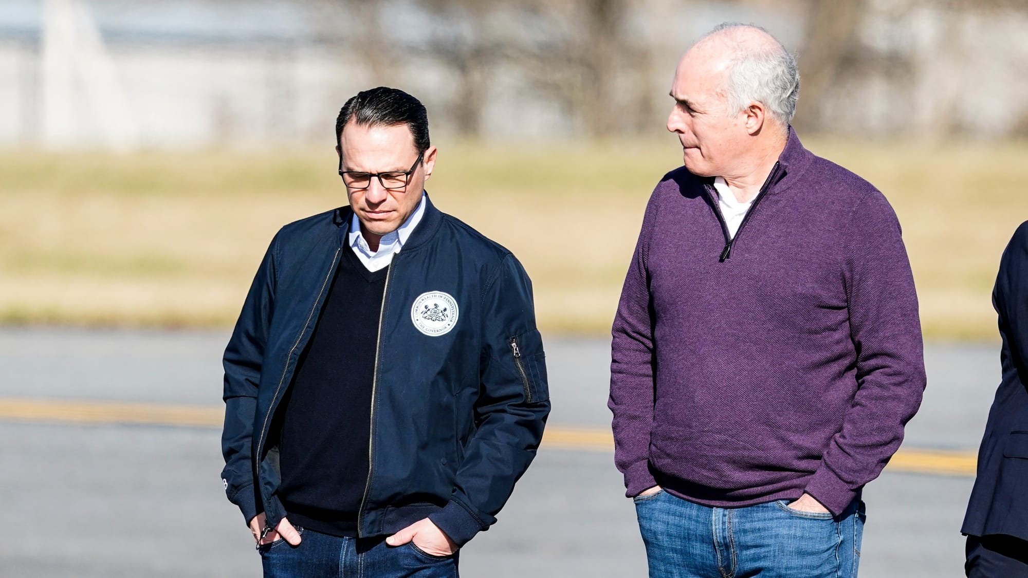 Pa. Gov. Josh Shapiro, left, and Pa. Sen. Bob Casey await President Biden. President Joseph Biden lands at Lehigh Valley Inte