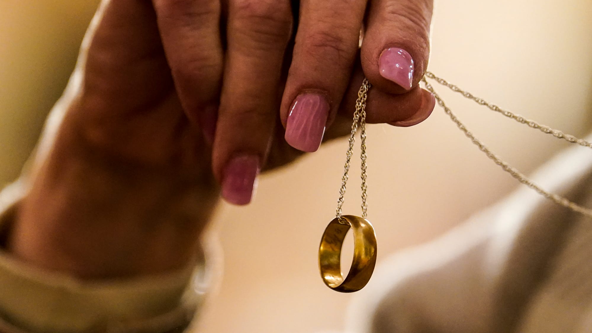 A woman shows her necklace which is her late grandmother's wedding ring. Grandmother was married in St. John's Windish, and t