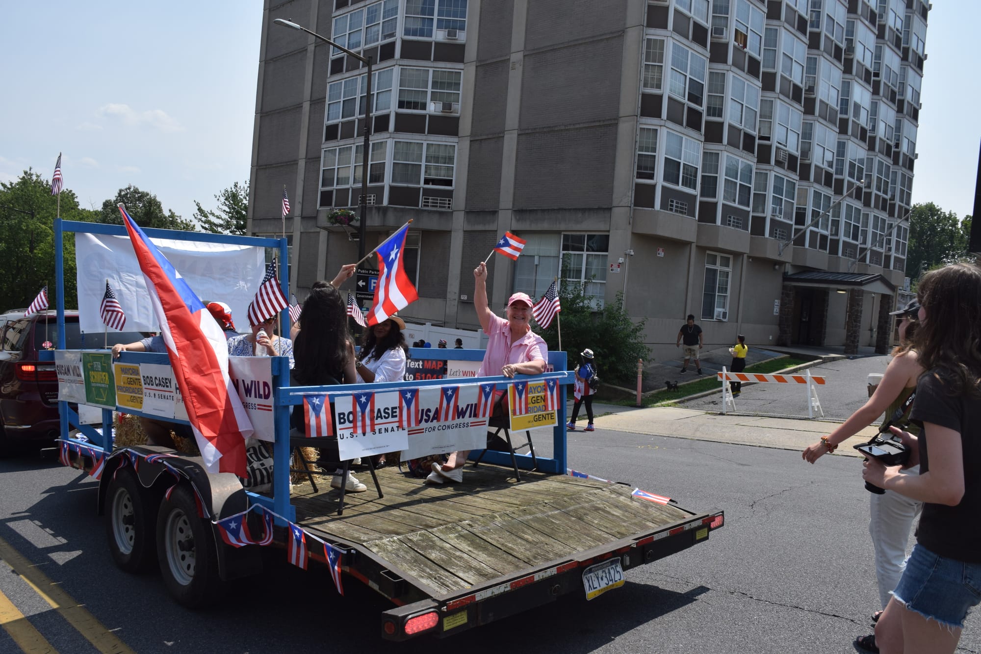 U.S. Rep Susan Wild (in pink shirt) waved the flag of Puerto Rico at the parade held July 28, 2024 in Allentown.