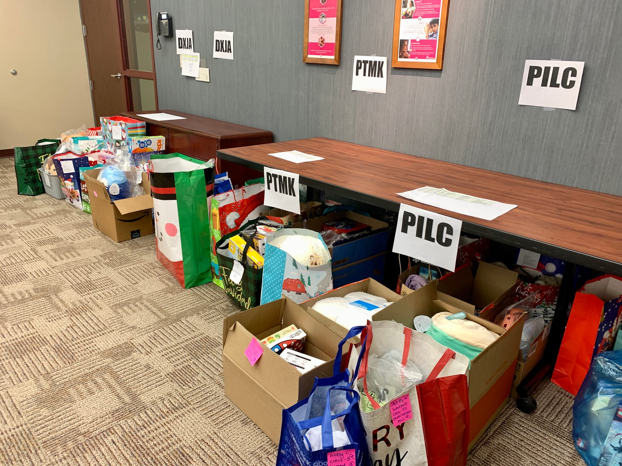 Bags and boxes of gifts donated to KidsPeace. The initials stand for the different residential homes the gifts will be sent t