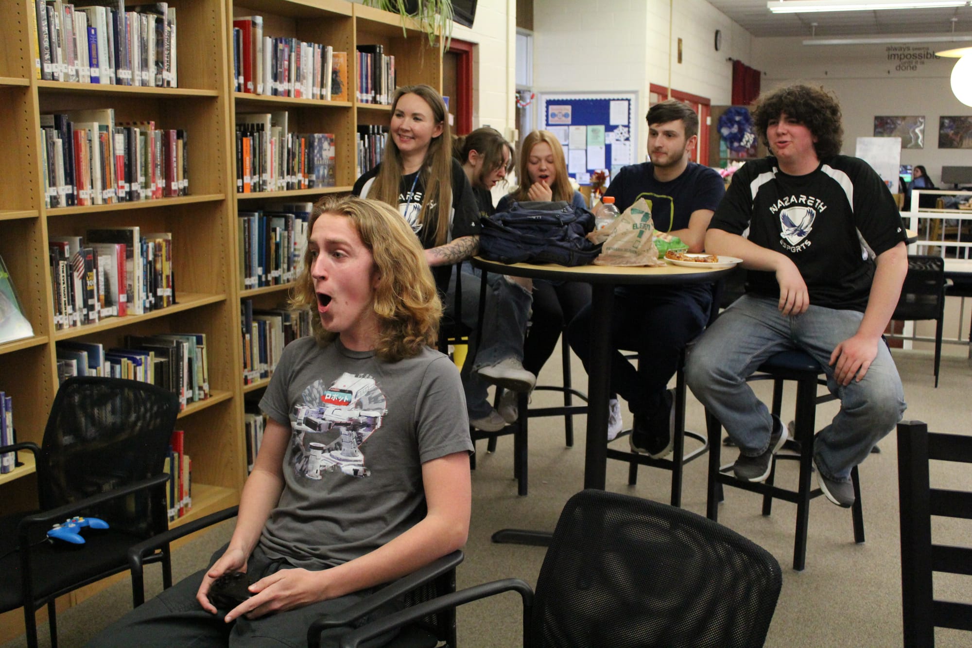 Competitor and broadcast manager Tristan Reiser reacts to a moment in his match as Strouse (left) watches with other students