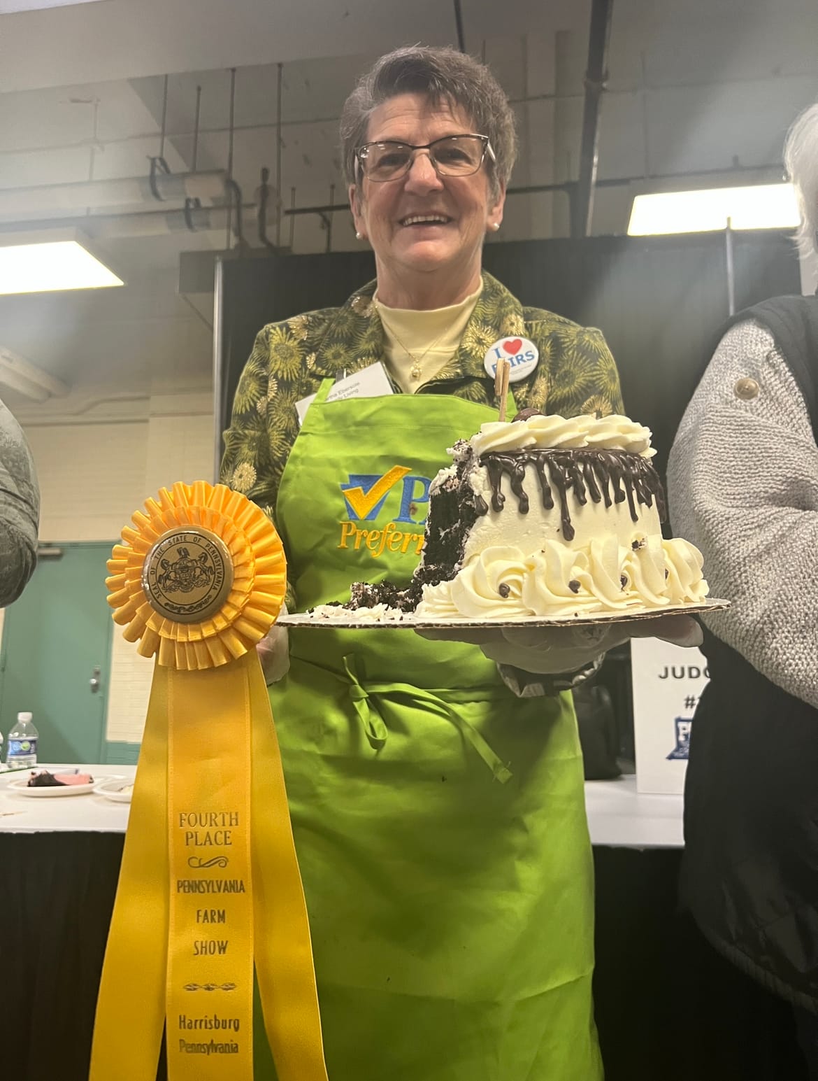 A volunteer holds Cindy Hendershot of Danielsville's fourth place chocolate cake at the 2023 Pennsylvania Farm Show.