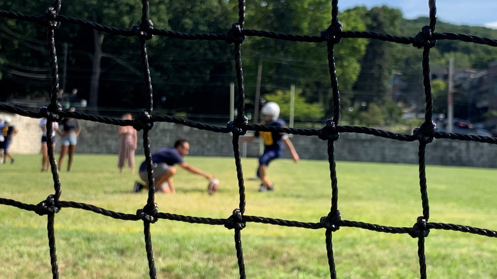 Sairett Rosario and Assistant Coach Charles Falteich work on kicking
