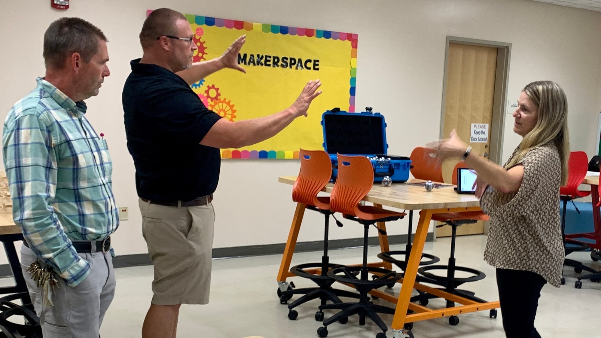 The SHINE teachers talk about the makerspace with a board member.