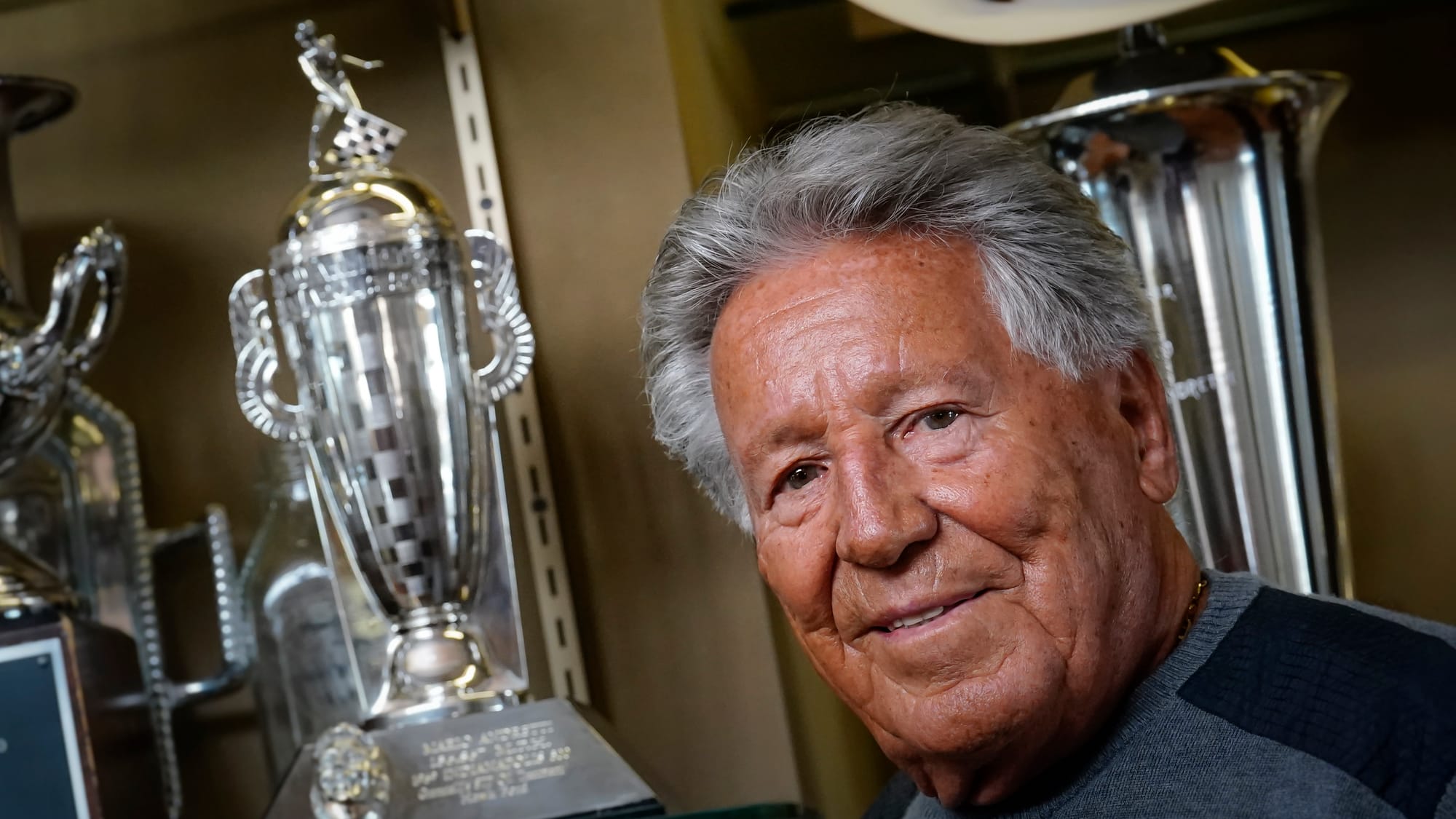 Race driver Mario Andretti shows his duplicate trophy from winning the 1969 Indianapolis 500. The original remains in Indiana