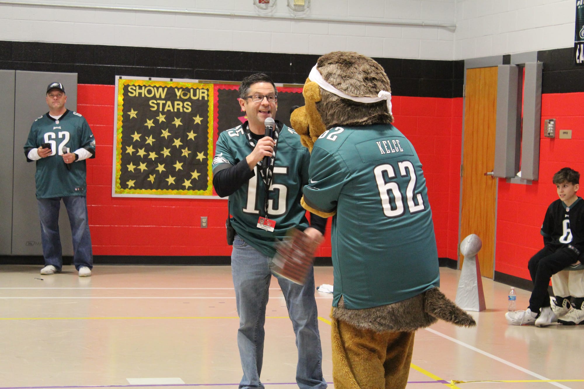 Dr. Jamie Giaquinto exciting the student crowd with the school's hedgehog mascot