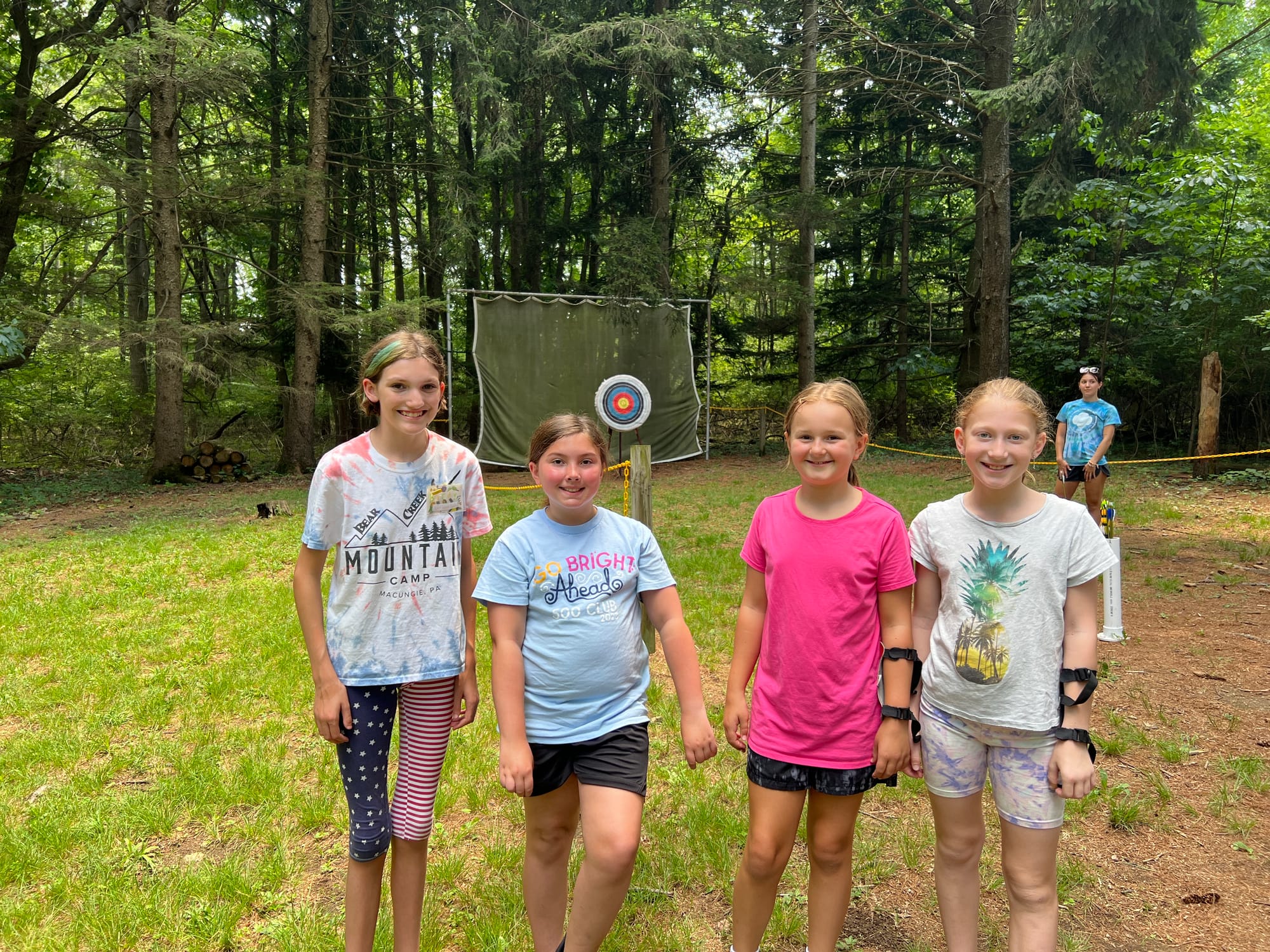 From left: Counselor Intern Birdie and Campers Caelyn, Charlotte and Cora pose at archery.