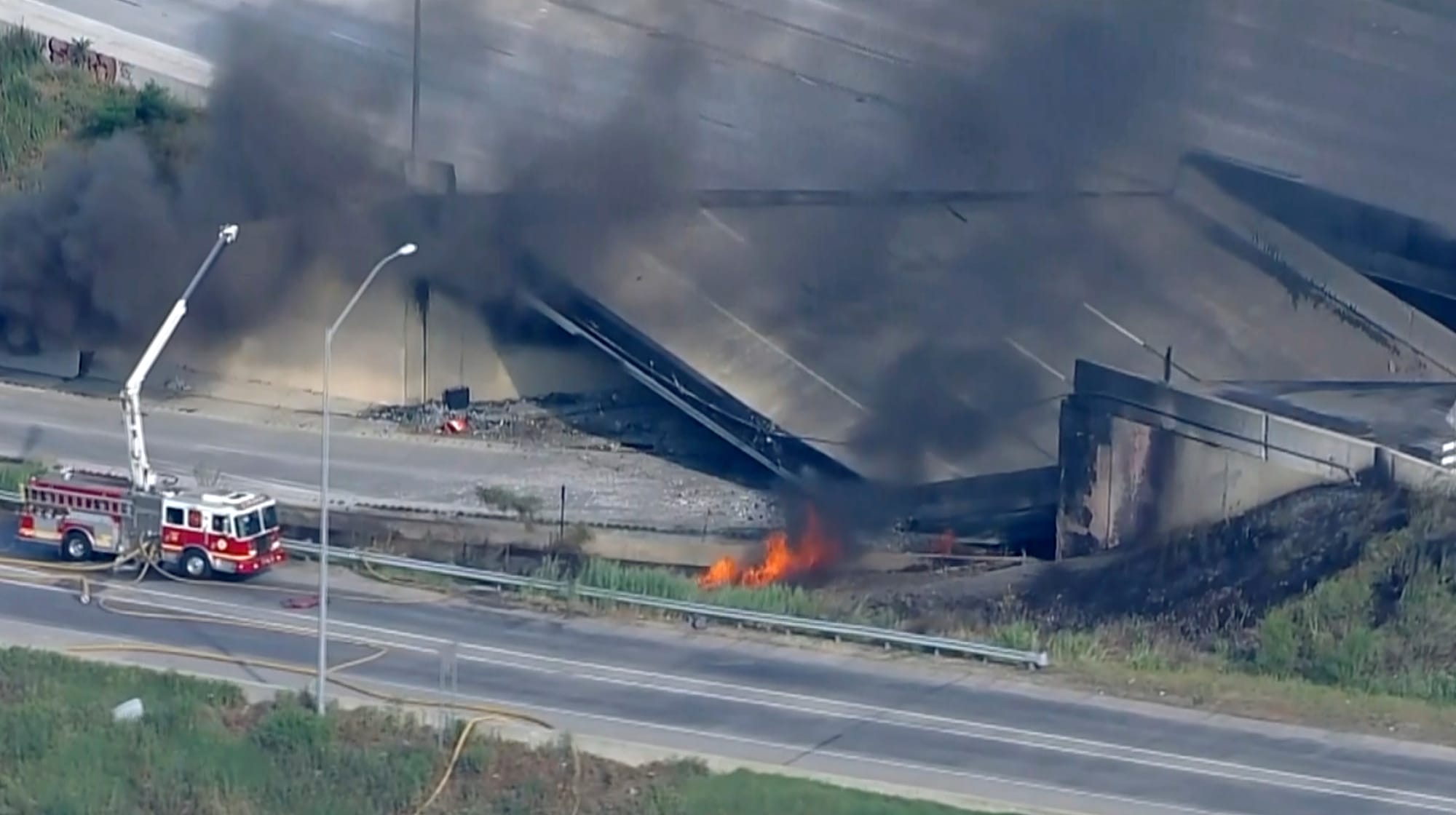 Officials work at the scene following the collapse of an elevated section of Interstate 95 after a tanker truck caught fire, 