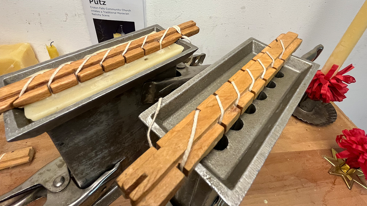 Molds for 6-inch yellow beeswax candles: Left, the mold, filled with wax, cools. On the right, wicks have been placed in the 
