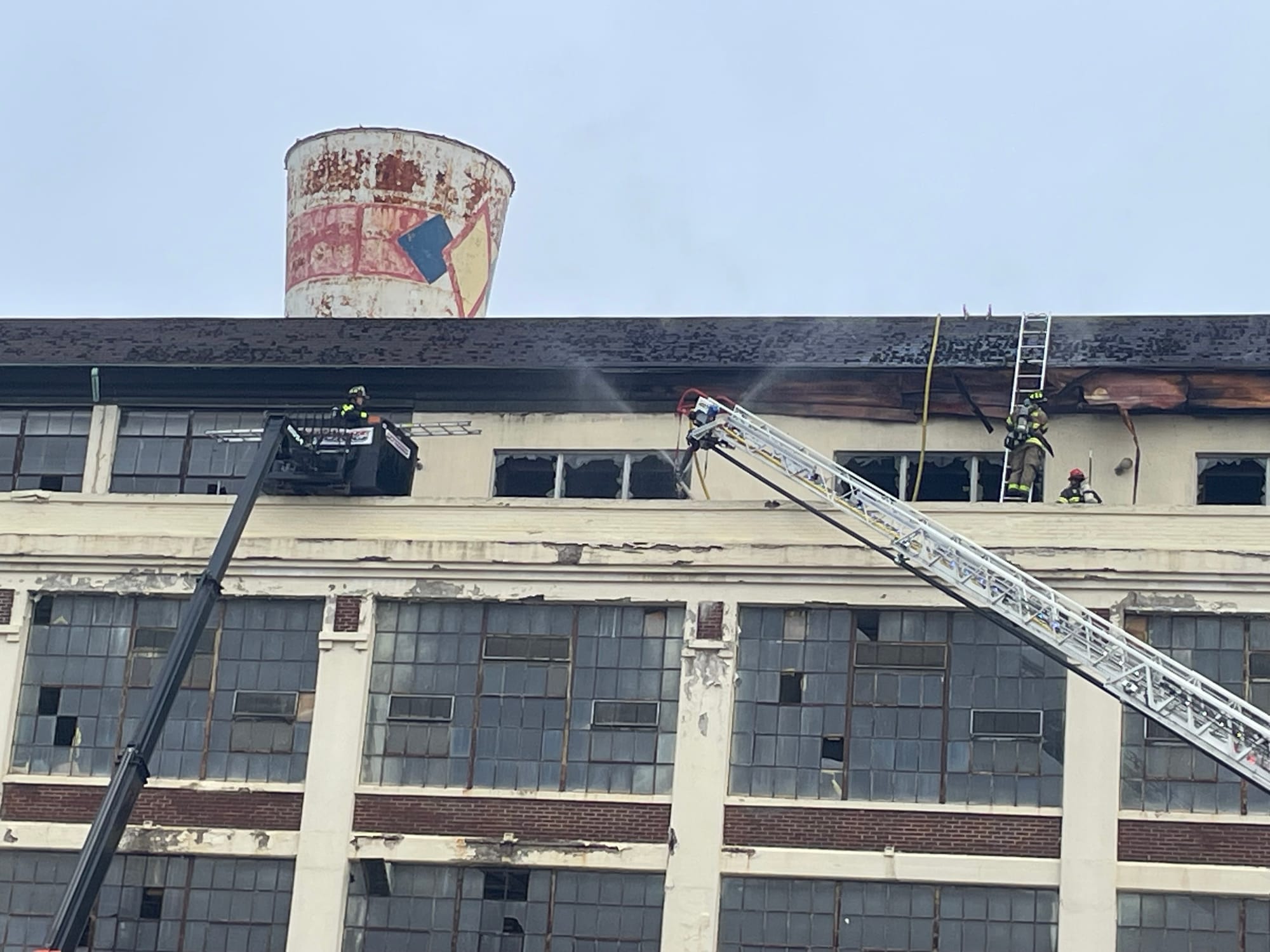 Firefighters on aerial ladders spray water on the old Dixie Cup factory in Wilson Borough after a fire broke out in the build