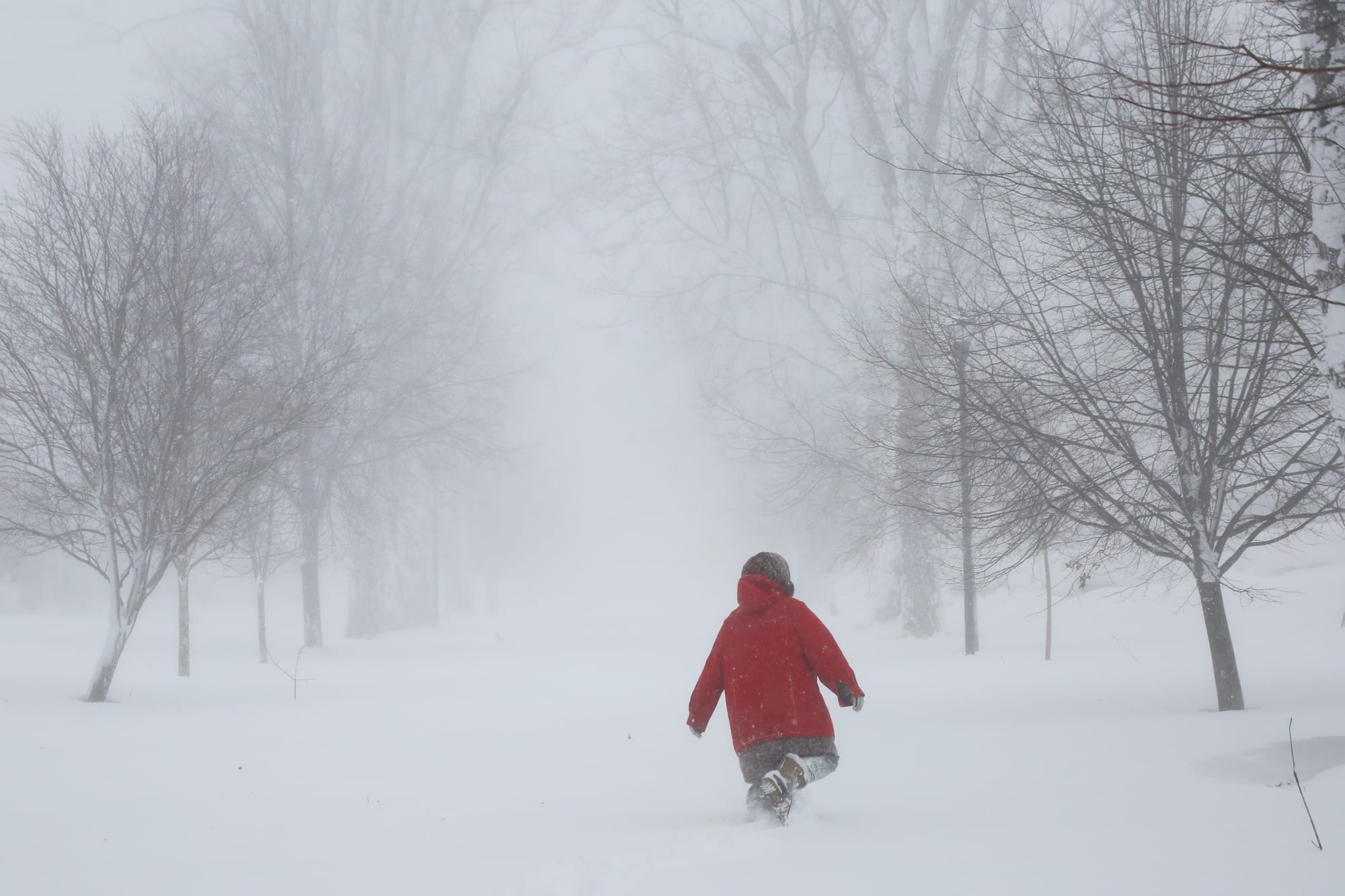 A person walks on the street as a winter storm rolls through Western New York Saturday, Dec. 24, 2022, in Amherst N.Y. A batt