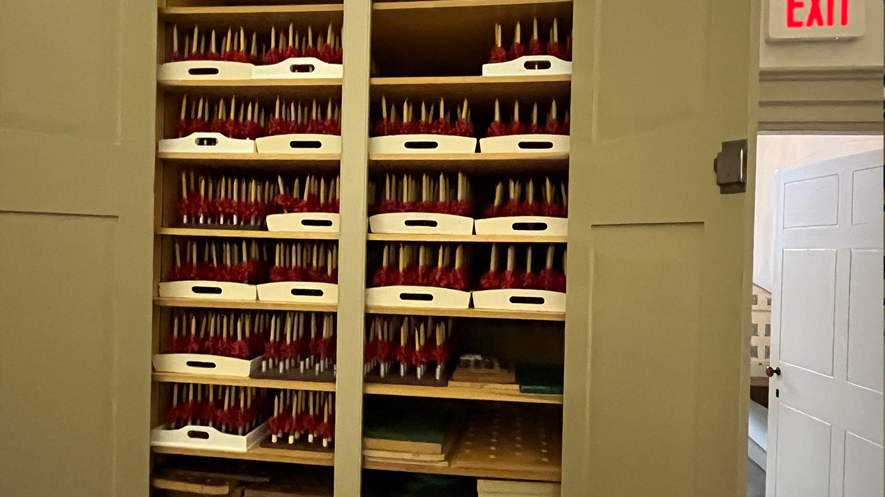 Trays of waiting 6-inch yellow beeswax candles line the storage shelves in the Kleiner Saal (meeting room) at Central Moravia