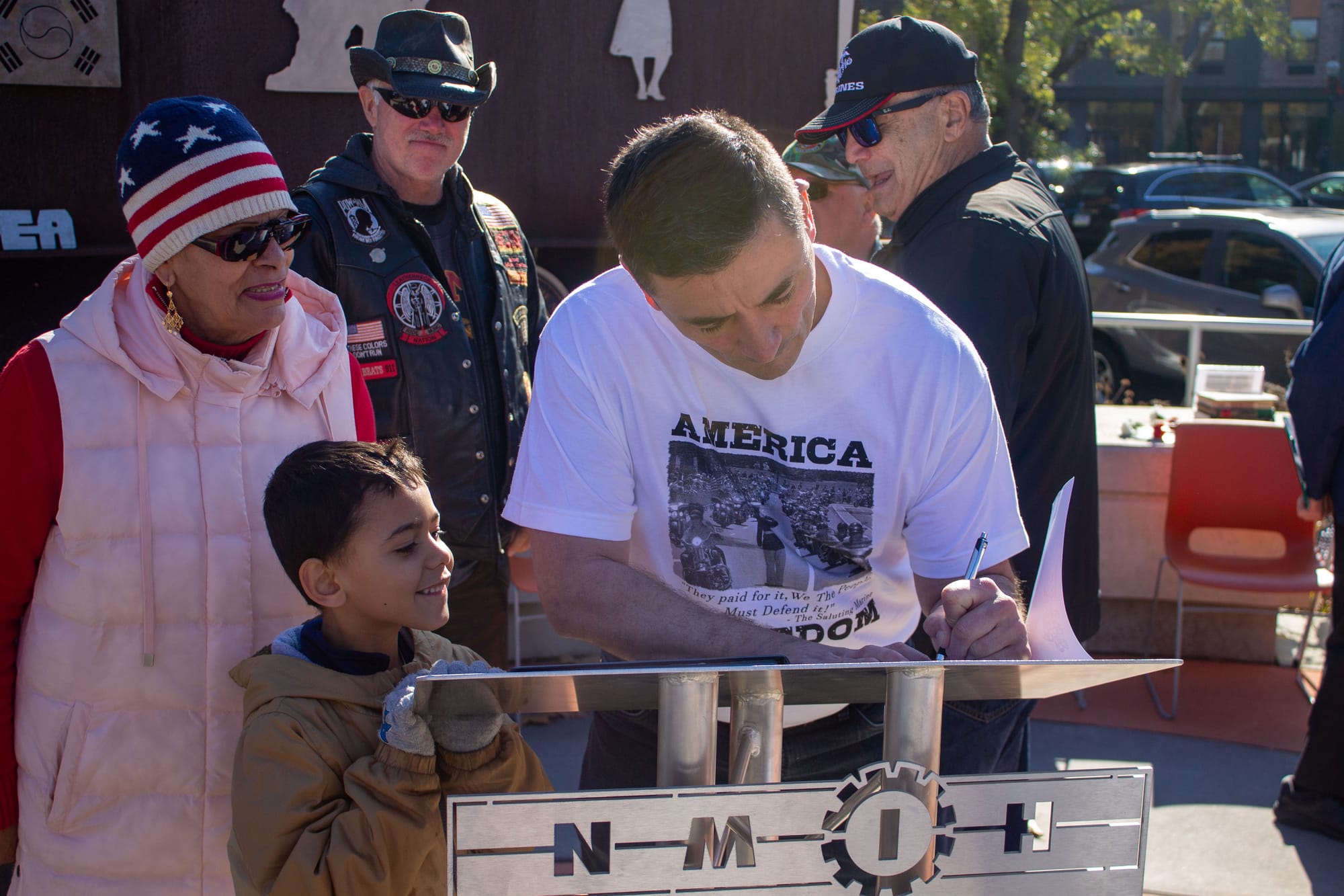 Tim Chambers, known as The Saluting Marine, signs a copy of his children's book for Amir.