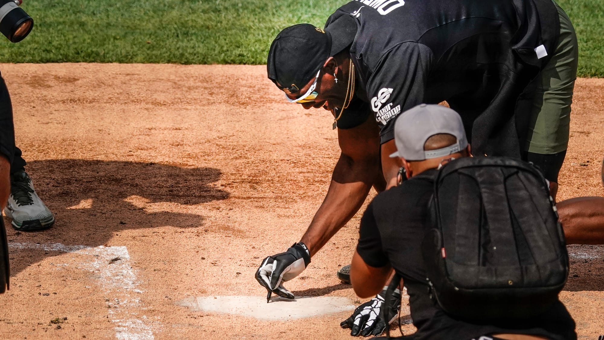 Terrell Owens, former Eagle, autographs home plate after hitting a home run. The 2nd annual DeVonta Smith Celebrity Softball 