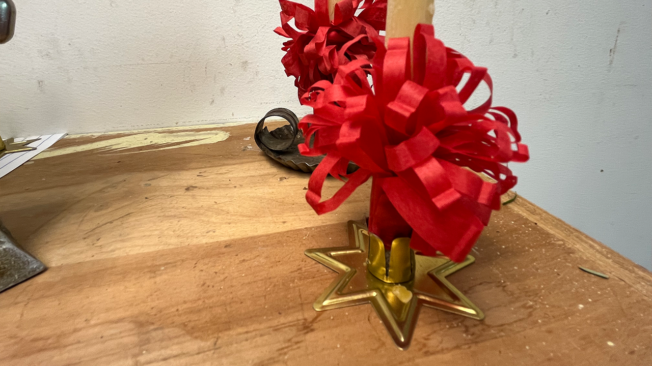 The finished effect of a 6-inch beeswax candle with a "bow."