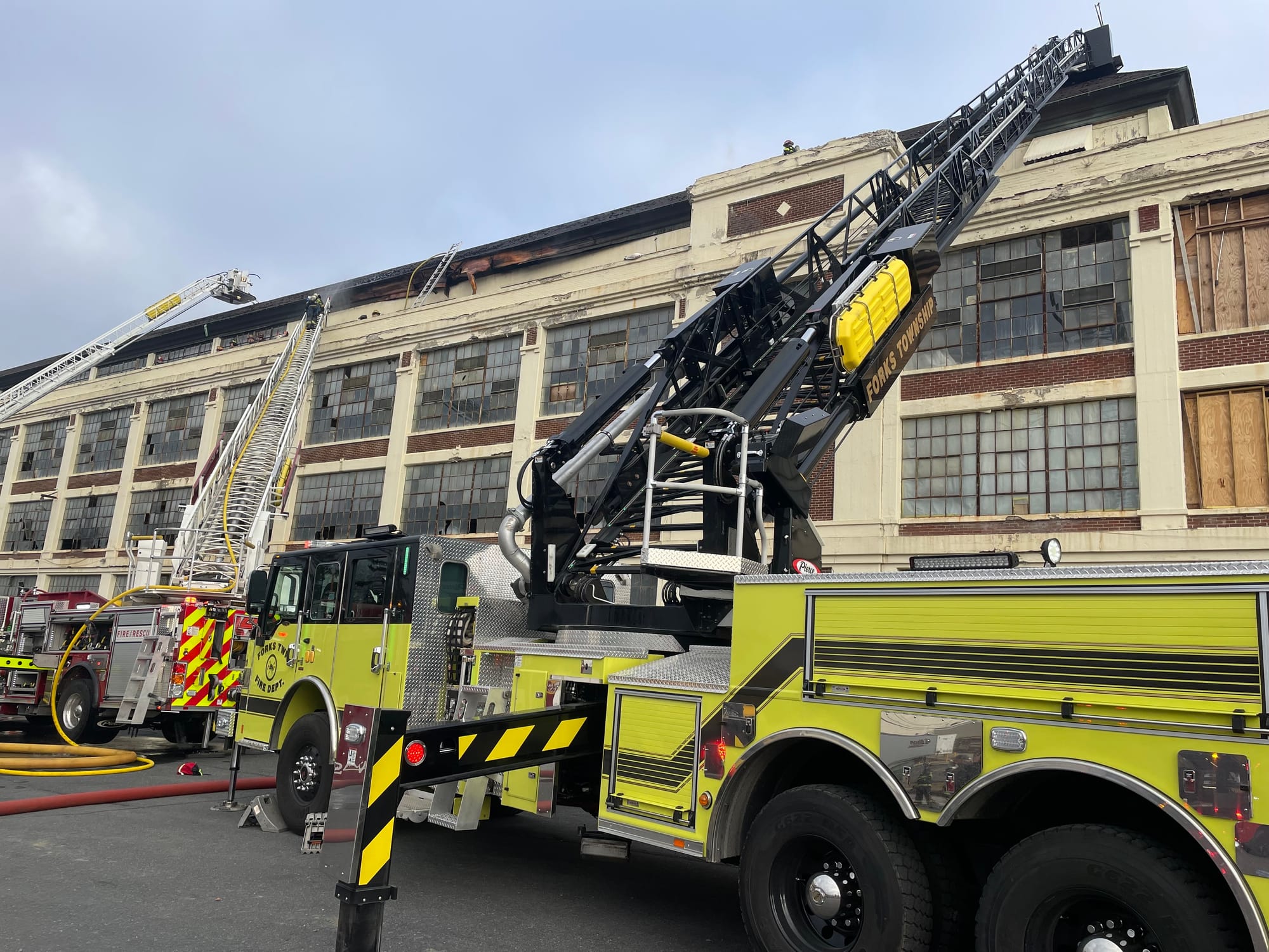 Forks Township firefighters assist at the scene after fire broke out in the old Dixie Cup factory in Wilson Borough early Fri