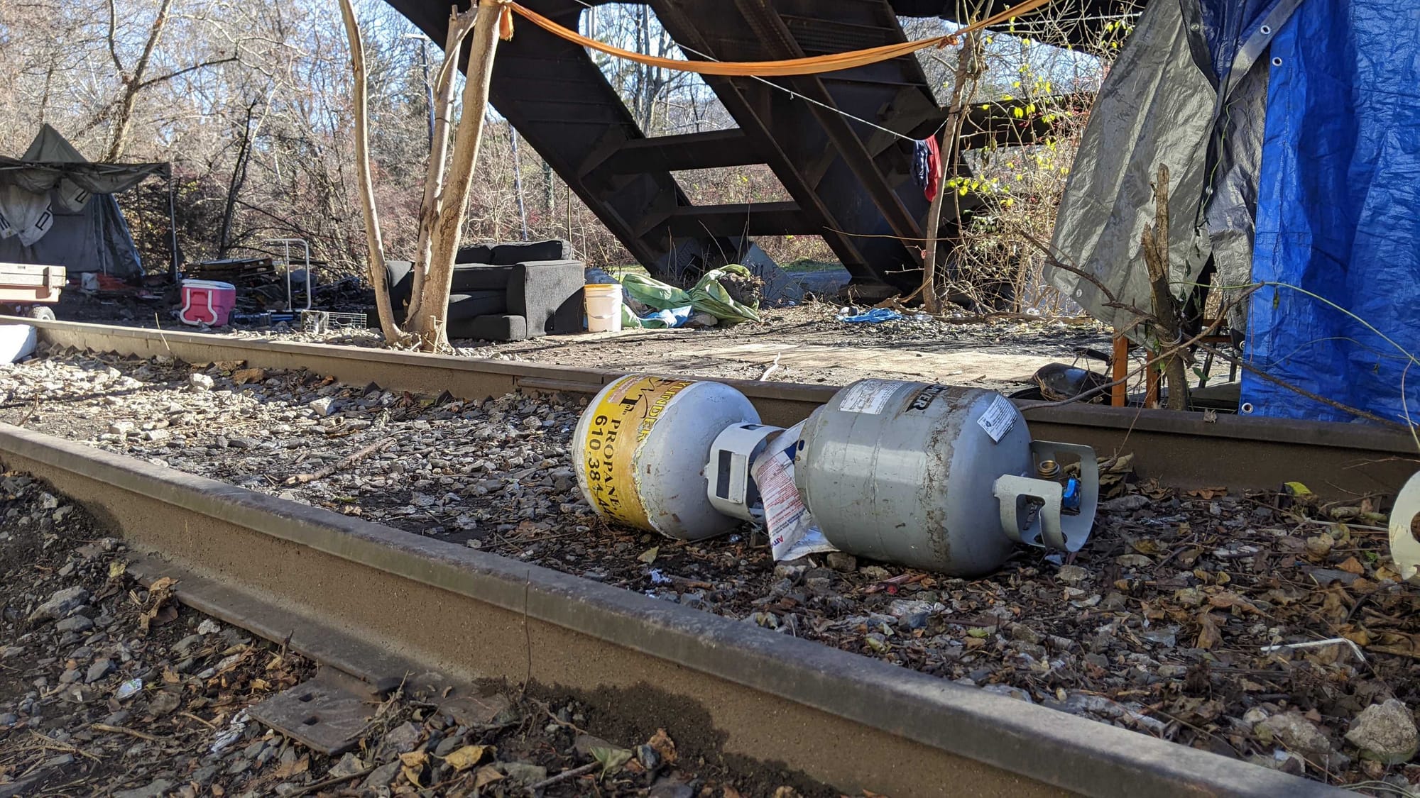 Police say two adult men were found with burns to their arms and hands following an early morning fire at an encampment under