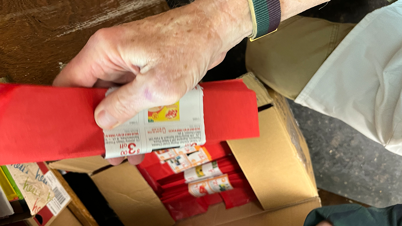 Volunteers dress the candles with red "bows" that start by folding pieces of red fire-retardant tissue paper.