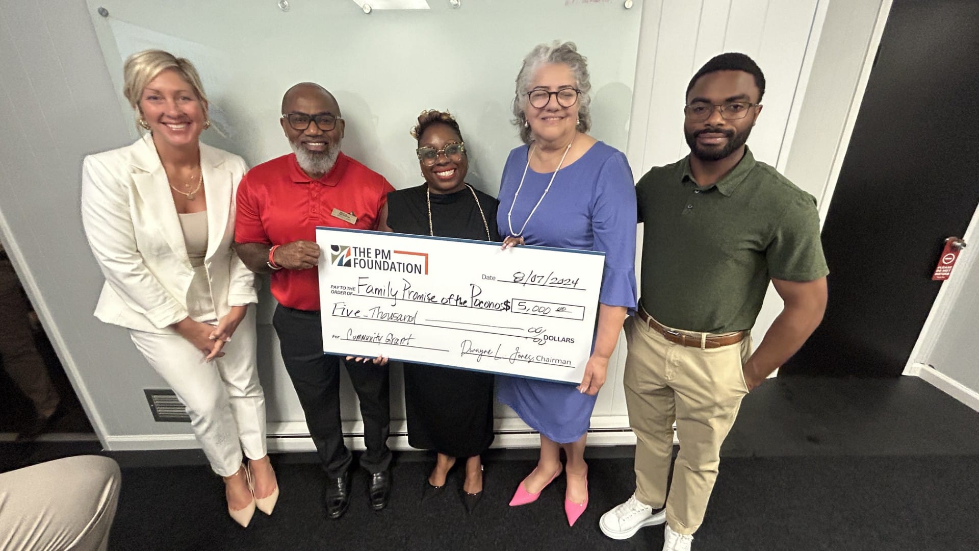 Family Promise of the Poconos executive director Timaki Johnson (middle) receives a check from the Preventative Measures Foun