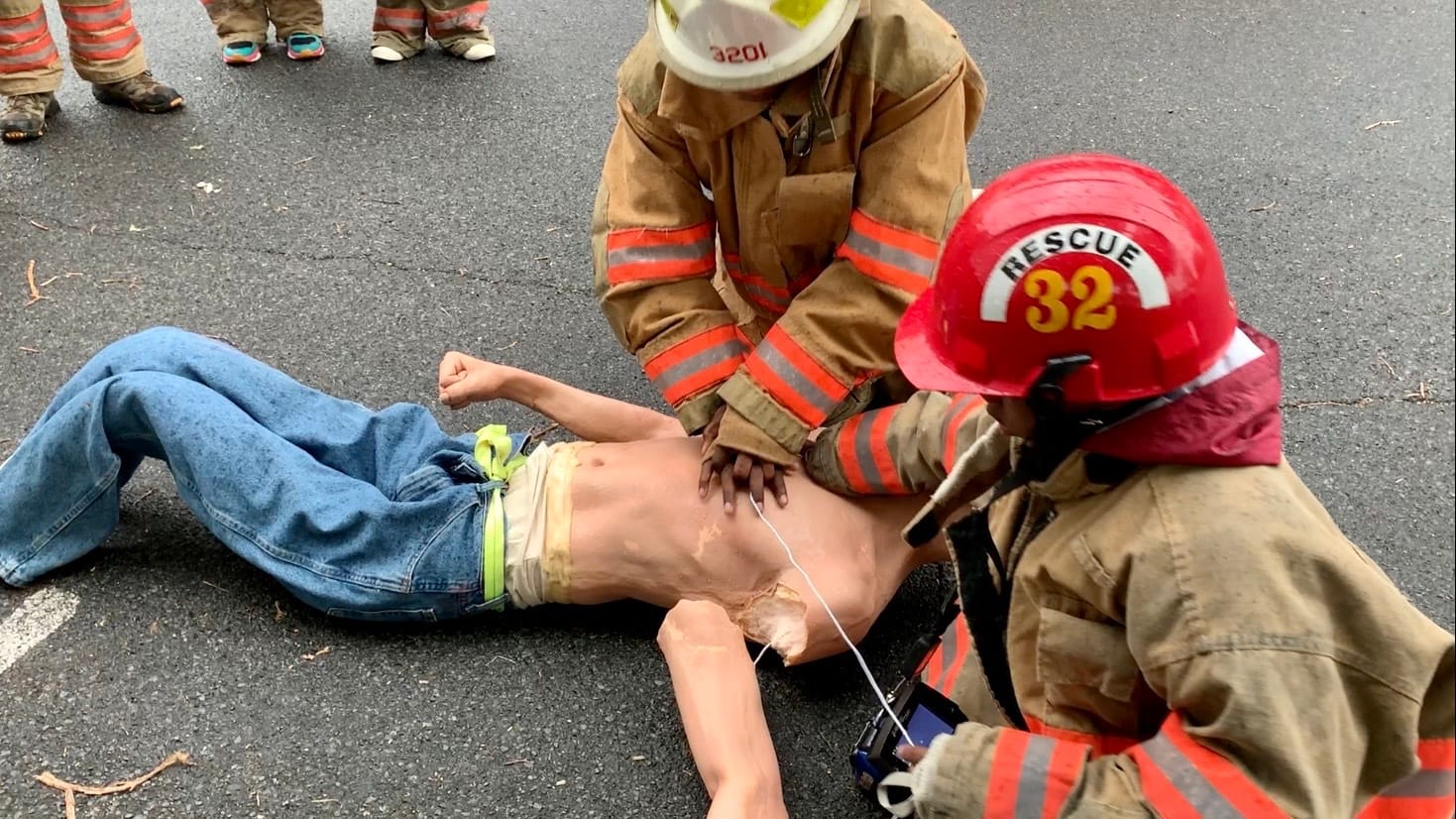 Camp attendees perform CPR on a mannequin.