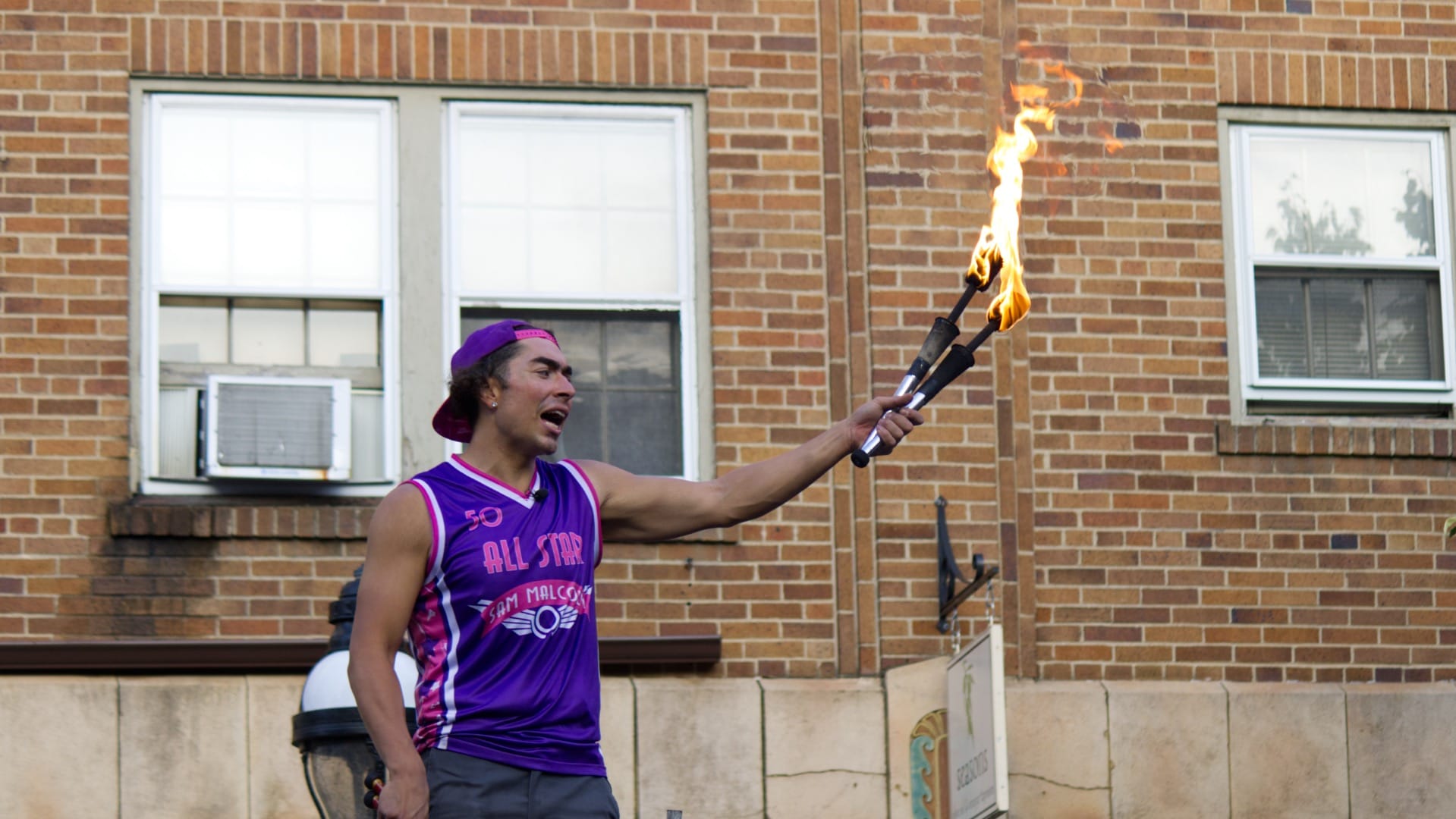 Sam Malcolm's jokes fly above the heads of some audience members, just like his juggled flaming torches.