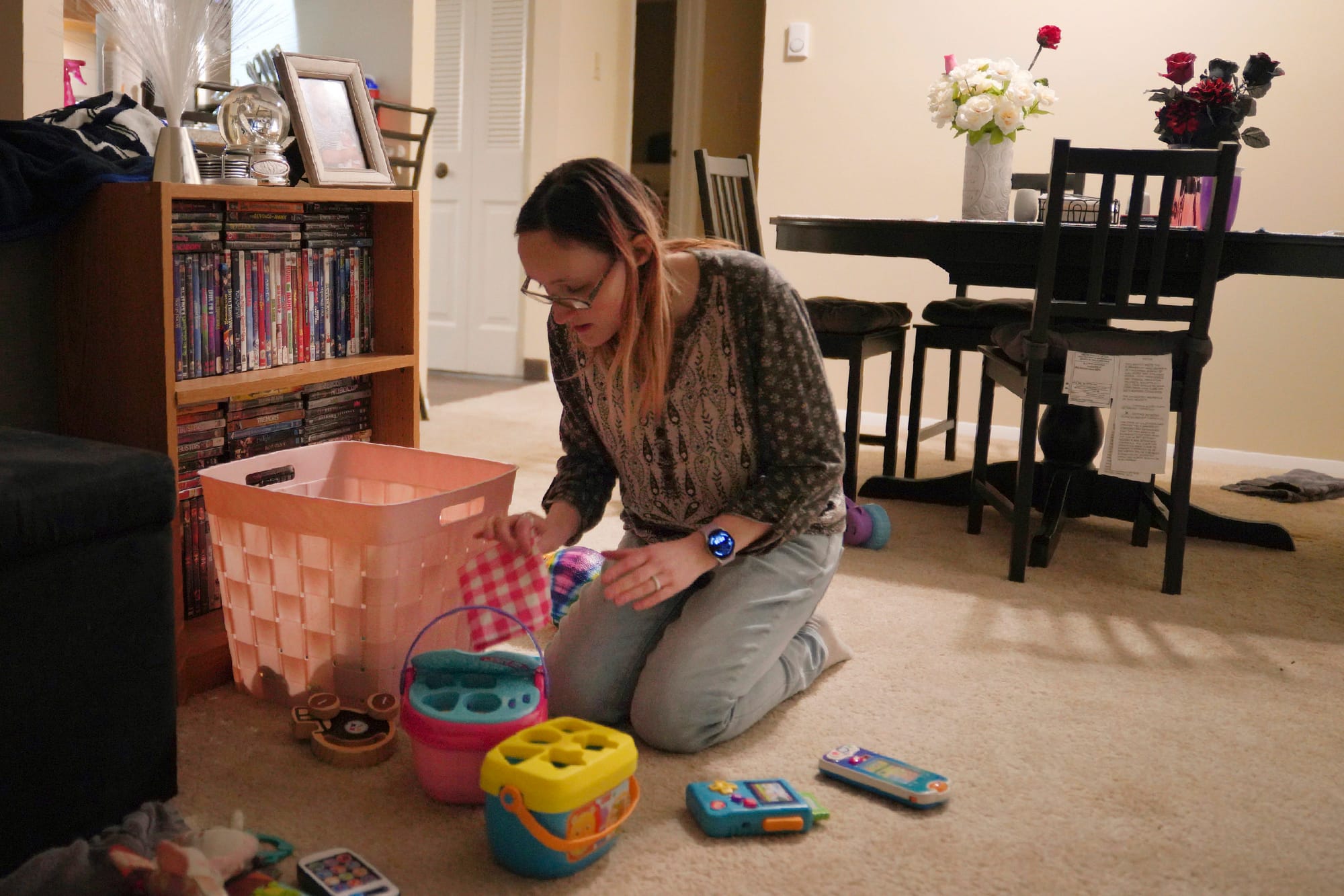 Lauren Hackney puts her young daughter's toys away after one of their twice weekly supervised visits, at their apartment in O