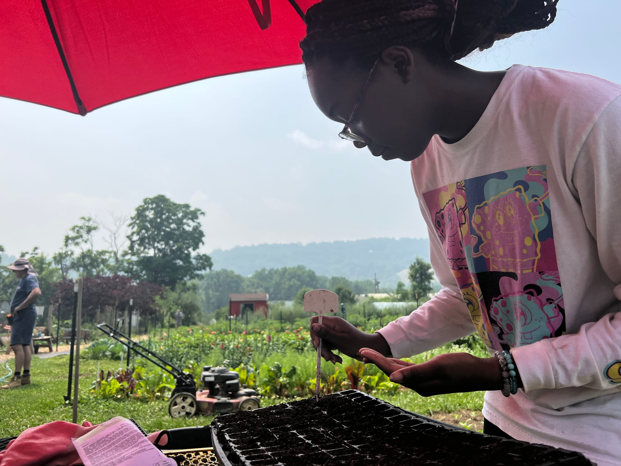 Layla Brown, gloves aside, planting beet seeds one by one.