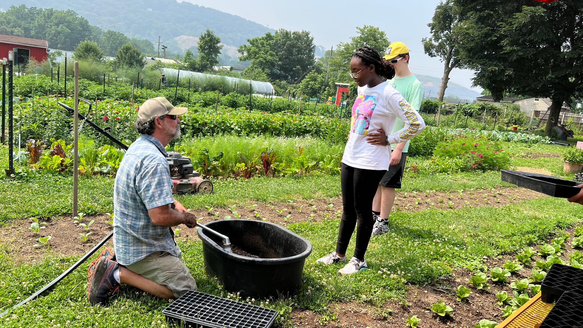 Farmer Mark Reid wets some dirt while explaining to interns why.
