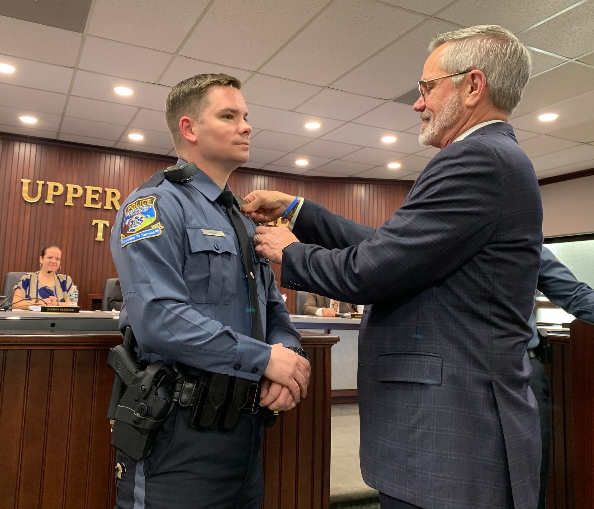 Officer Riley Miller has his badge pinned by his father, who was also a police officer.