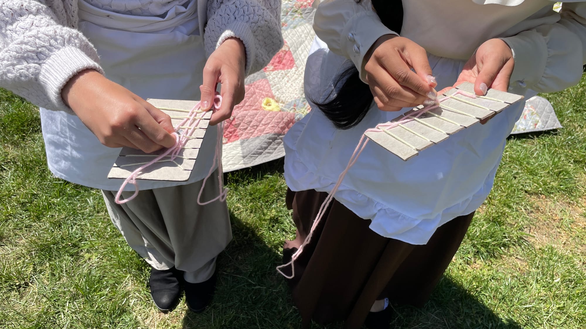 The girls demonstrate the over-under weaving technique.