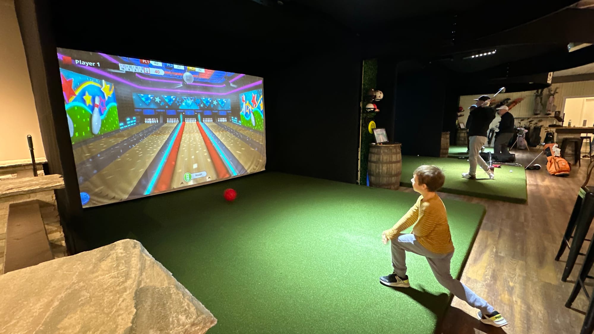 Luke Booser, 7, scores a strike in a bowling simulator at Twisted Tees.