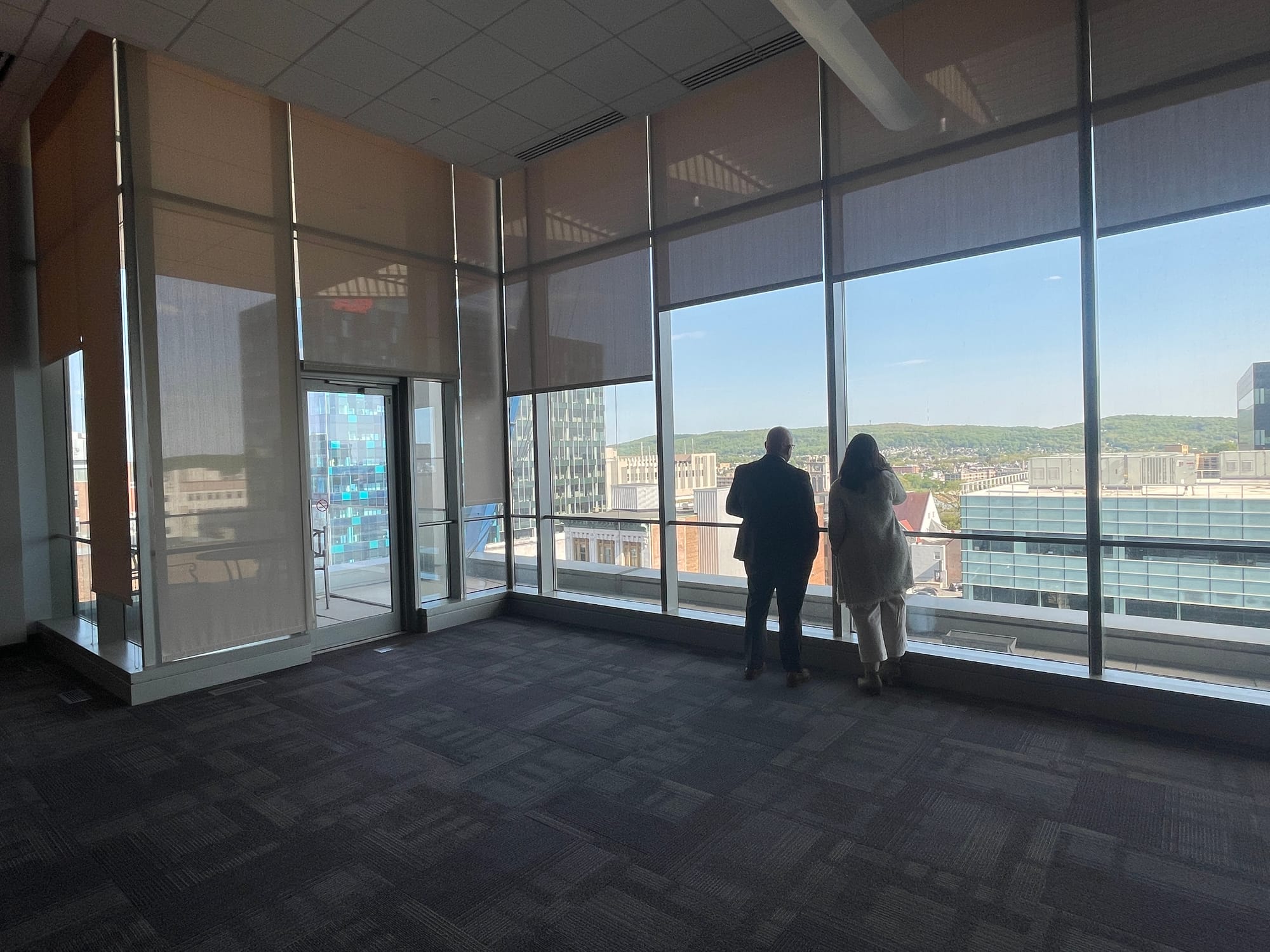 On the seventh floor of a neighboring building, people watched as the final beam was placed with a crane.