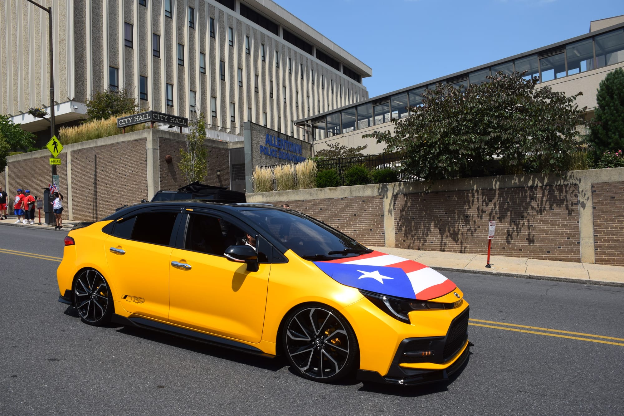 Cars adorned Puerto Rican flags as drivers and passengers waved to parade attendees in Allentown.