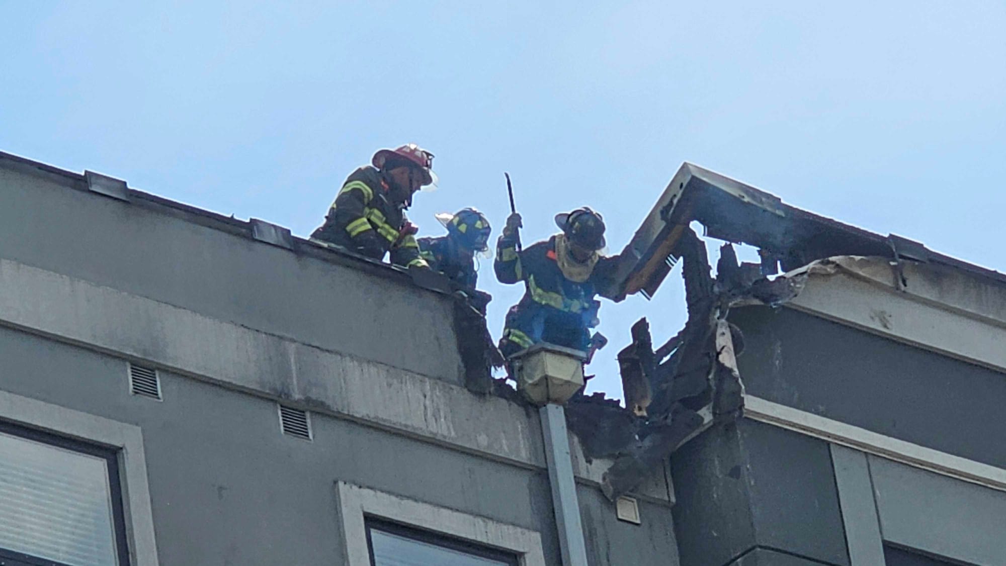 Firefighters assess damage to the top of the Five10 Flats apartment building in Bethlehem where a fire broke out Friday after