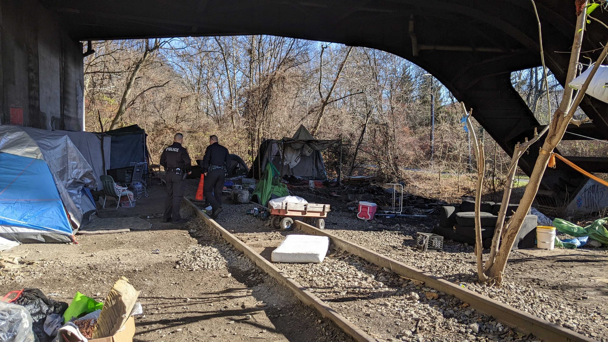 Police say two adult men were found with burns to their arms and hands following an early morning fire at an encampment under