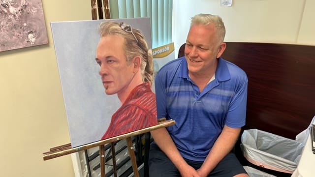 Doug Reinford looks at his self-portrait, which is on display at the Artists in Recovery exhibit.
