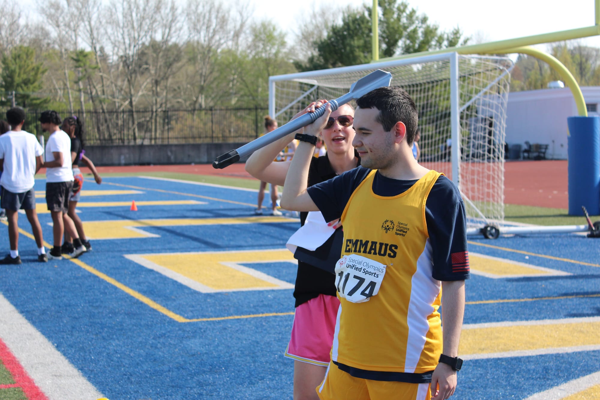 Students from Emmaus High School Unified Track and Field coach Emily Schwartz assisting an athlete throwing a min-javelin