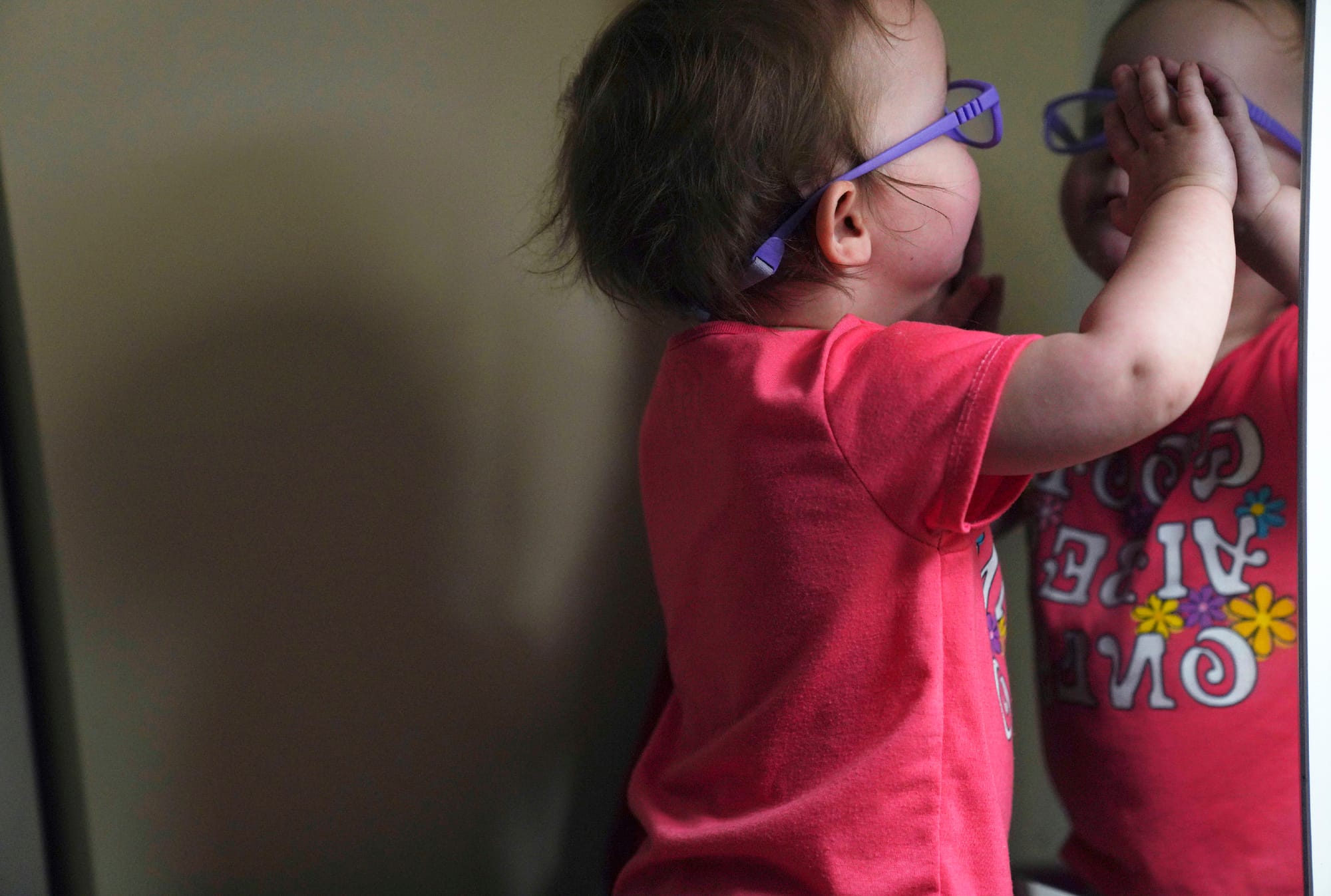 The Hackneys’ daughter looks at her reflection in a bedroom mirror during a supervised visit at her parent's home in Oakdale,