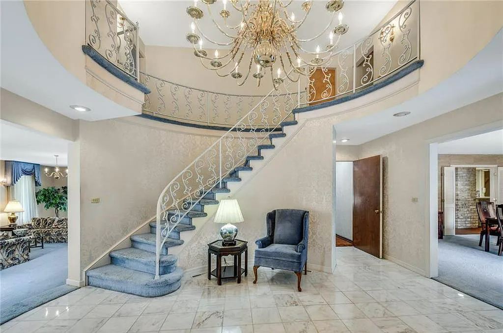 A curved staircase with blue velvet carpets