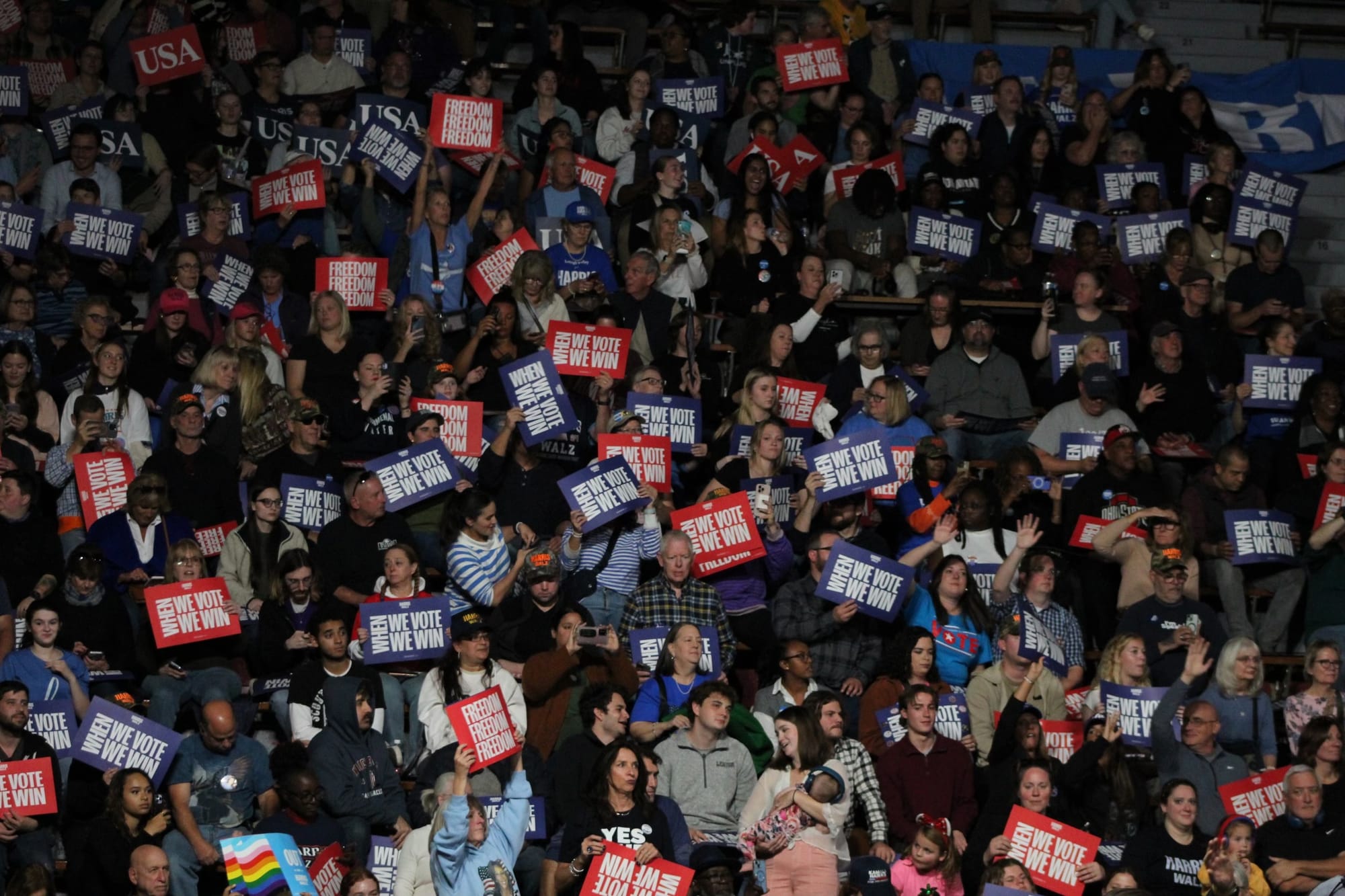 The audience waves signs saying "WHEN WE VOTE WE WIN" at Vice President Kamala Harris' rally at Muhlenberg College in Allento