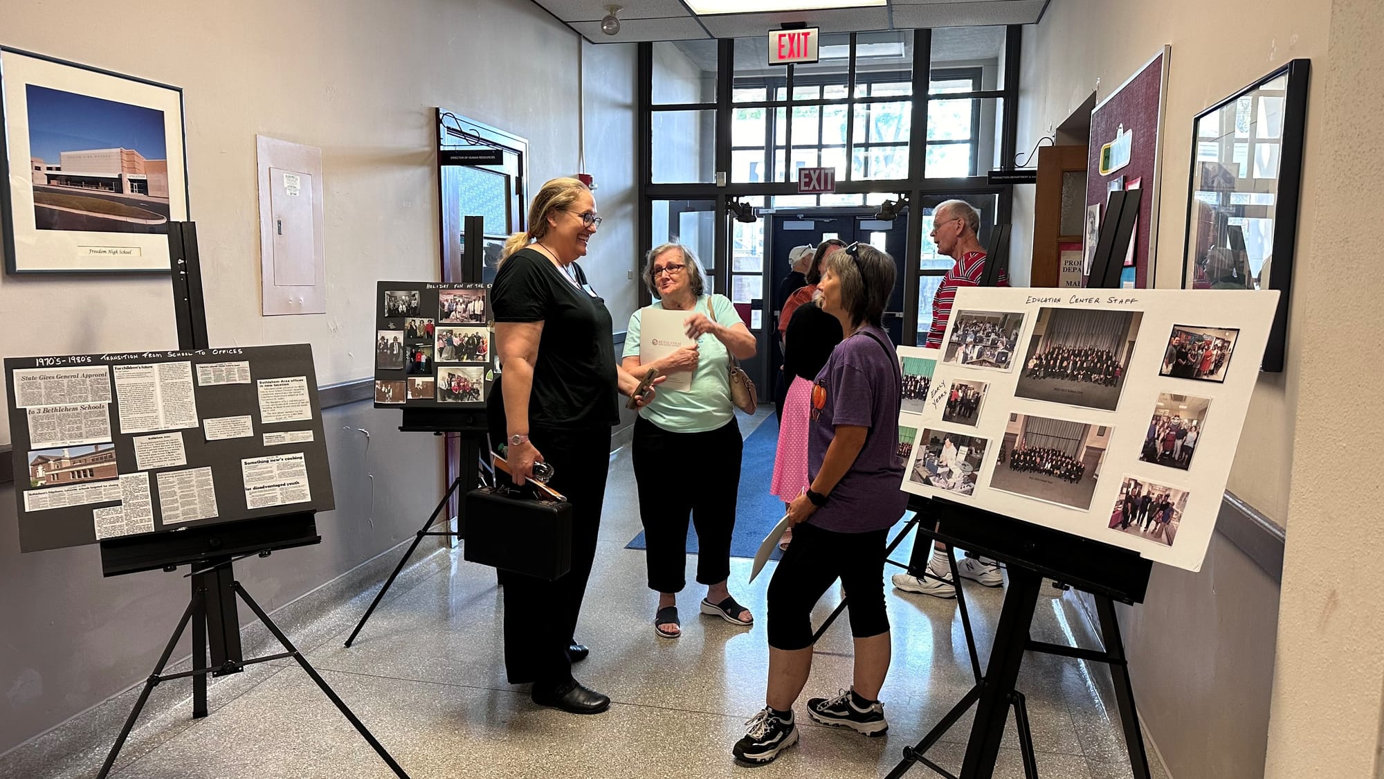 Former classmates chat as they look over class photos at the Edgeboro Elementary School centennial celebration.
