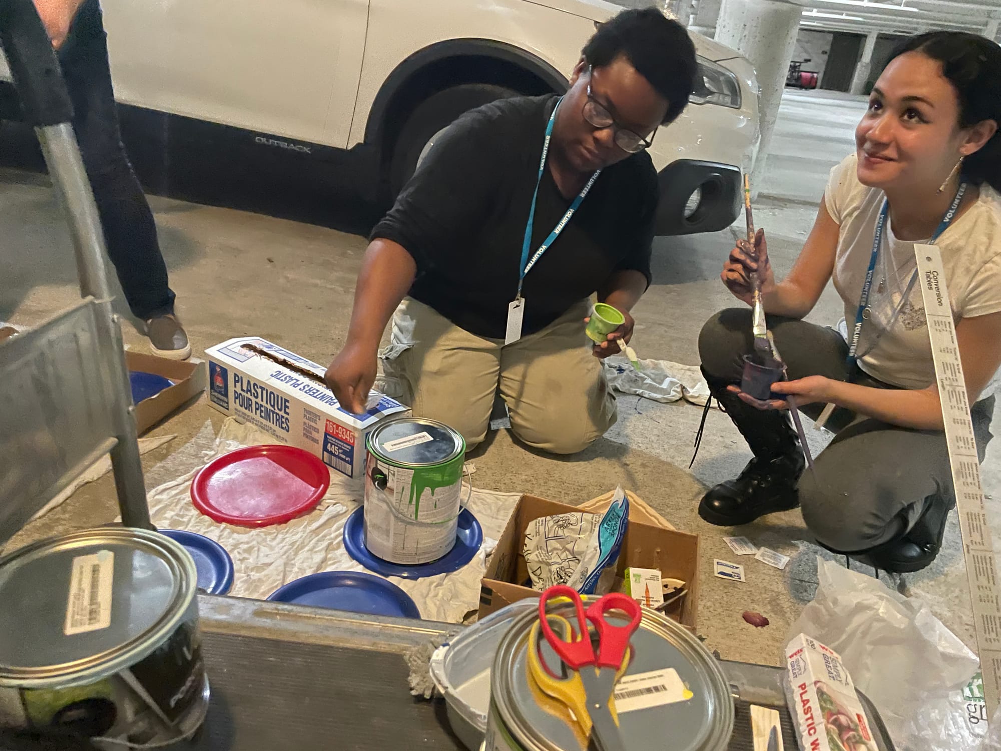 Nalah Brown (left) and Jaelyn Merced (right), both students at Freedom High School, prep new colors for painting.
