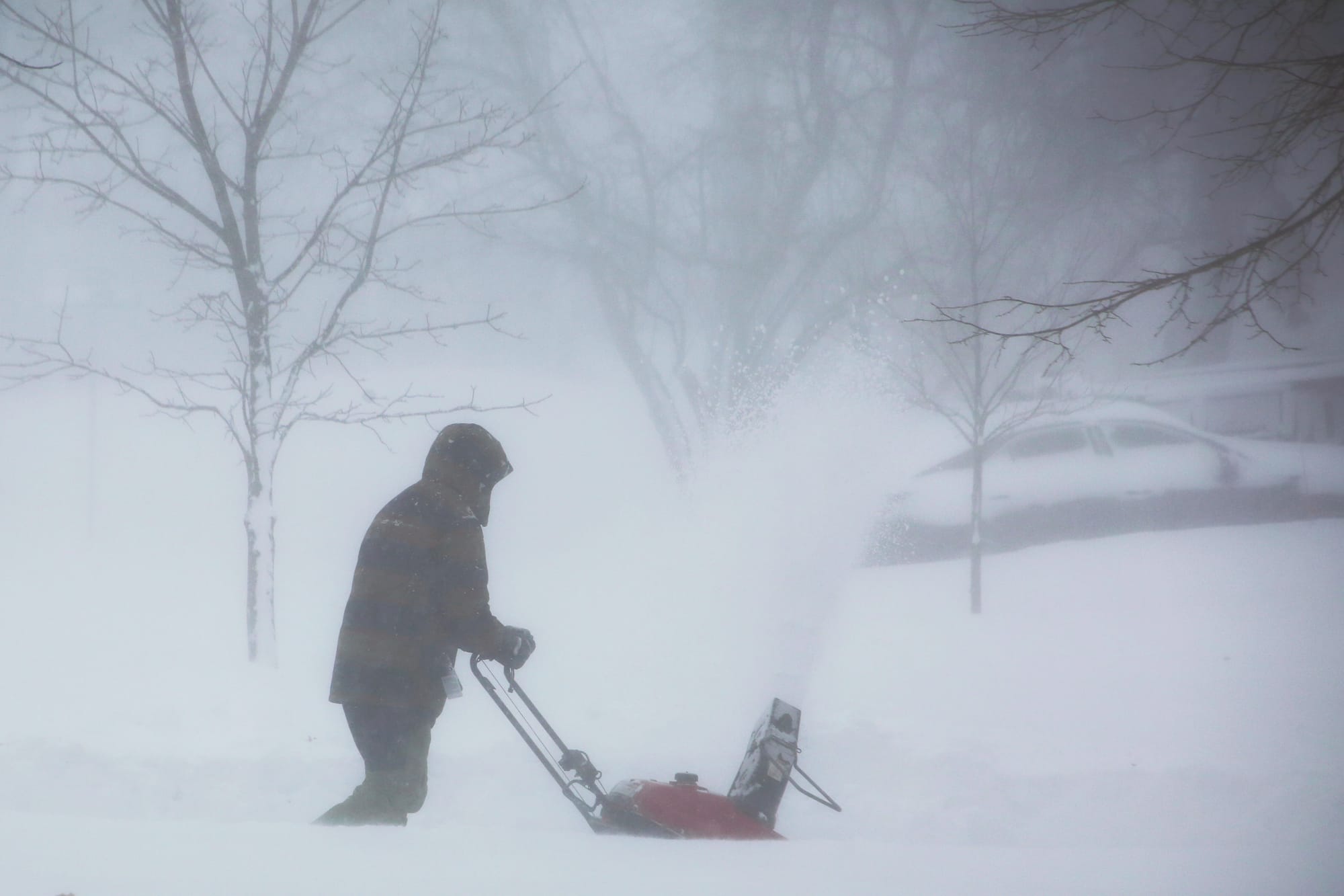 A person clears snow as a winter storm rolls through Western New York Saturday, Dec. 24, 2022, in Amherst N.Y. A battering wi