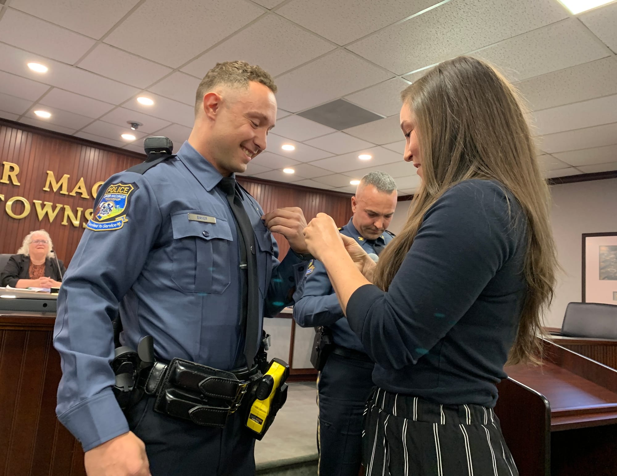 Officer James Baker Jr has his badge pinned by his fiance.