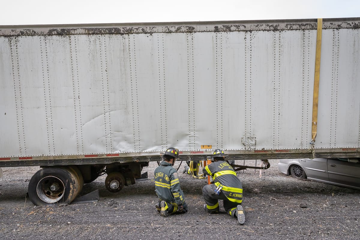 Firefighters work through a scenario involving a car under a tractor-trailer during a training event in Palmer Township on Ma