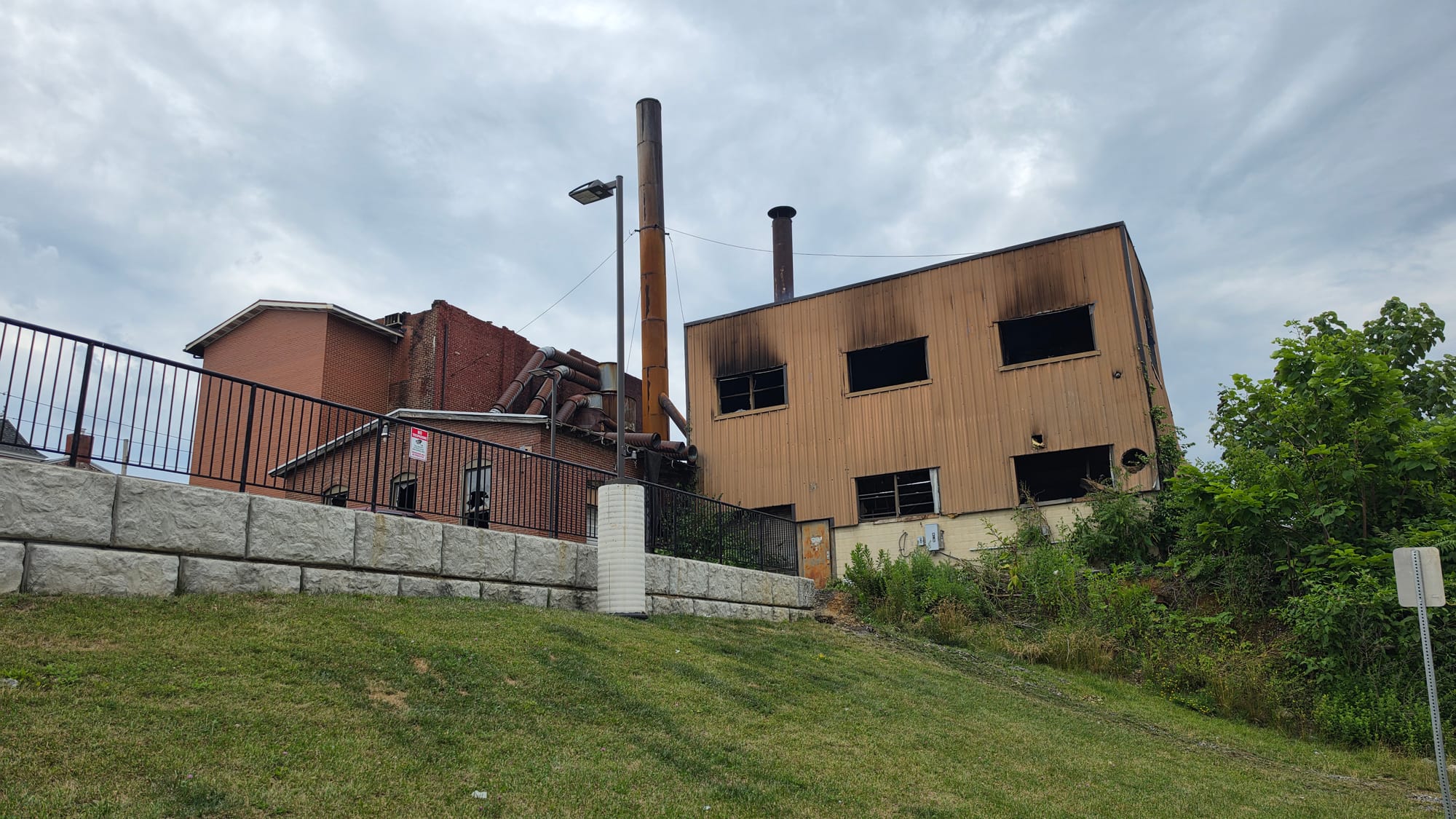 The burned out remains of the former American Atelier furniture factory on Front Street continued to smolder Thursday, June 2